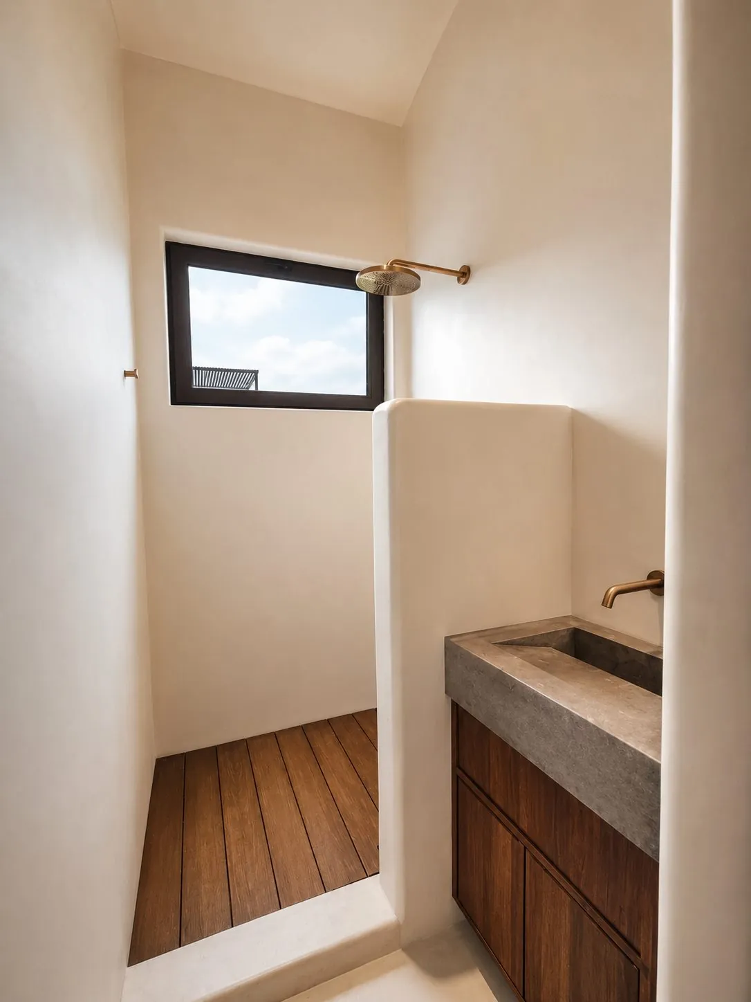 Baño con regadera, piso de madera y lavabo de concreto en Casa Aria